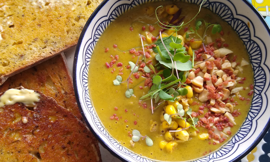 Spicy Cajun broccoli soup served hot with a handful of colourful mixed microgreens as garnish.