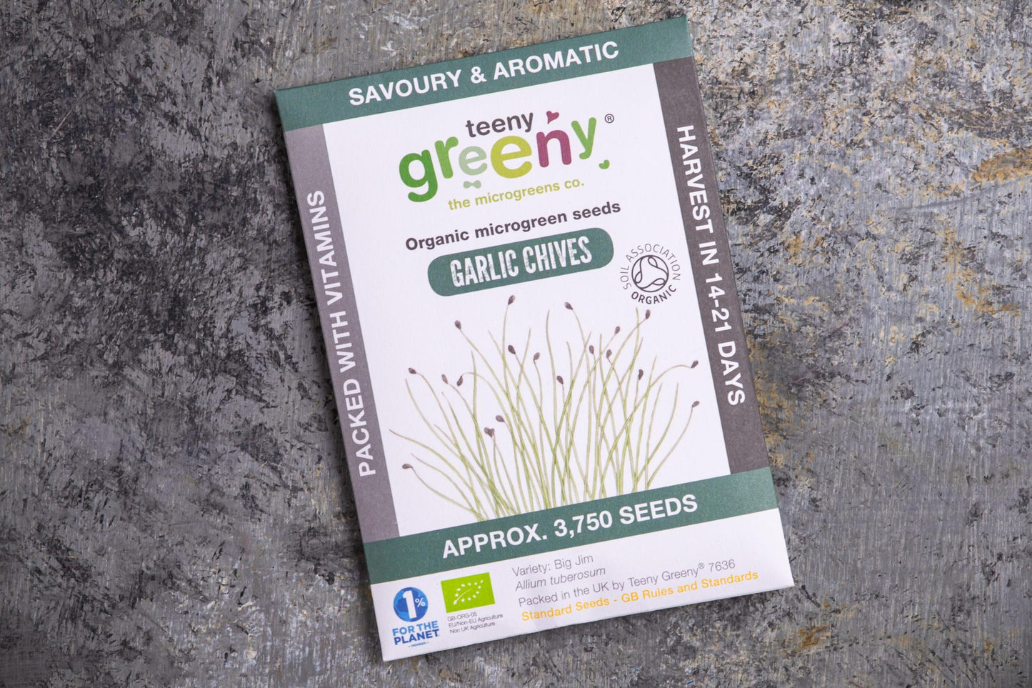 Teeny Greeny organic garlic chive microgreen seeds packet flat lay on stone surface