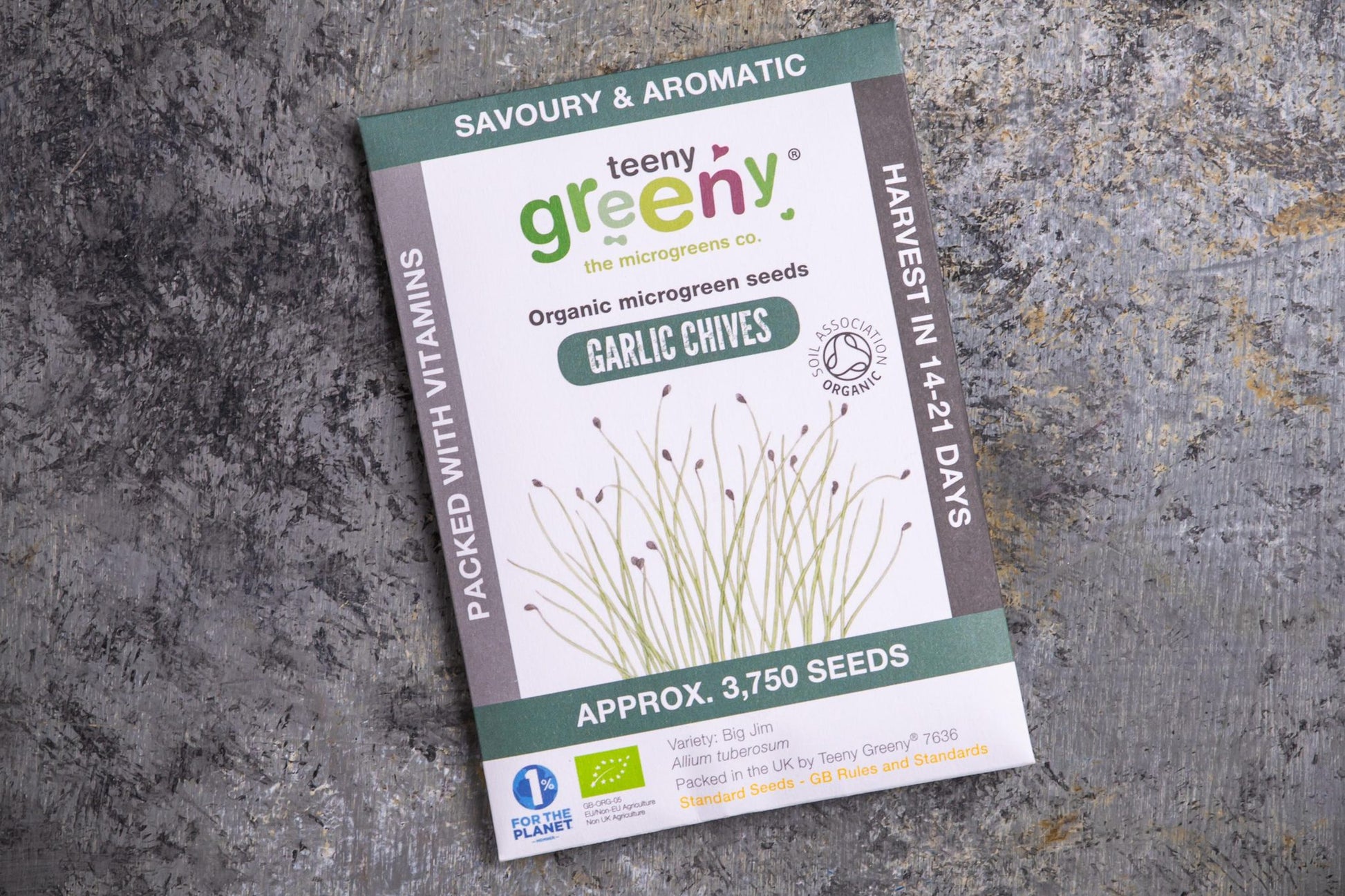Teeny Greeny organic garlic chive microgreen seeds packet flat lay on stone surface