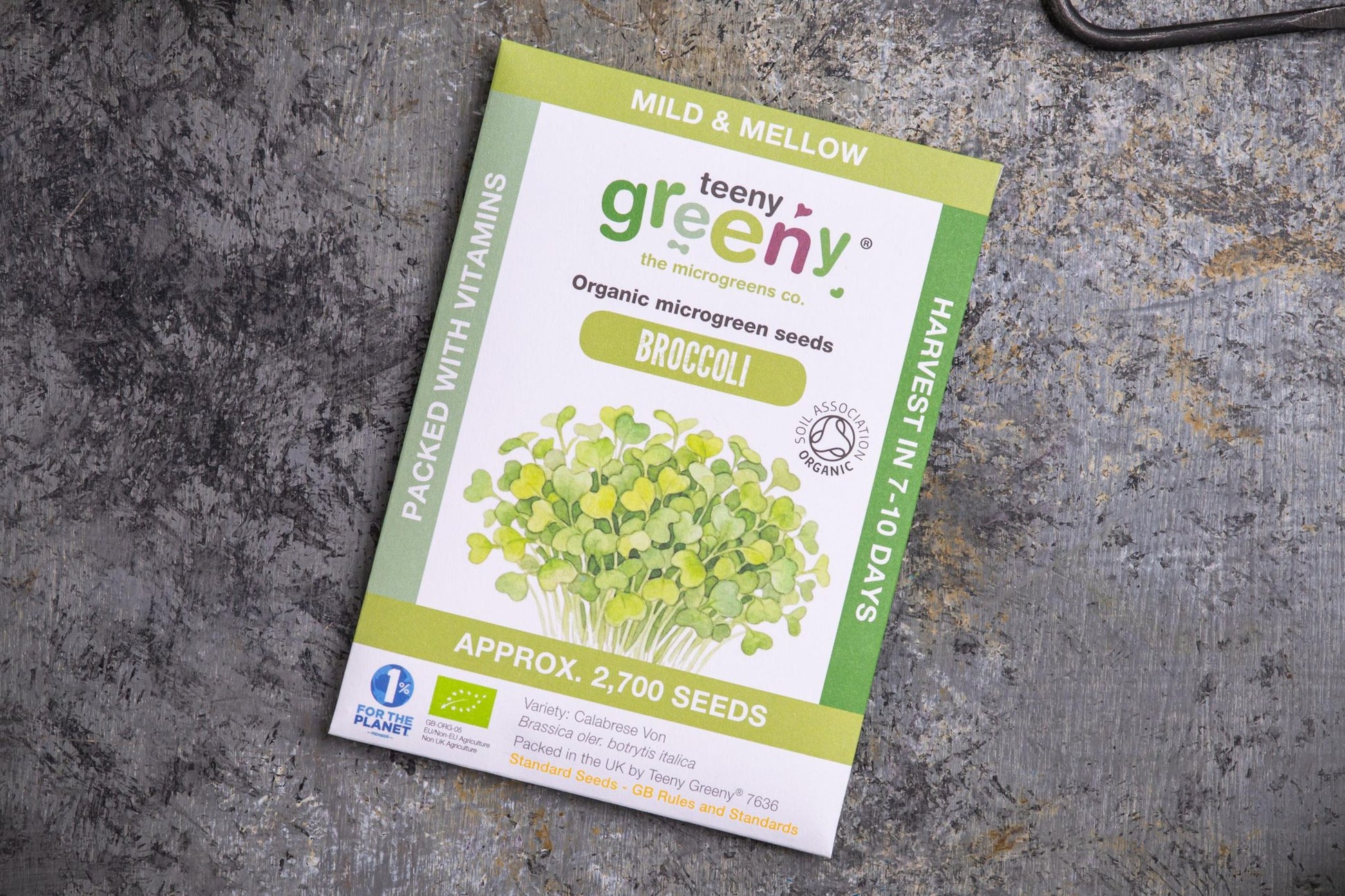 Teeny Greeny organic broccoli microgreen seed packet flat lay on stone surface