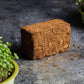 Teeny Greeny coir briquette growing medium for microgreens on dark stone surface with microgreen bowls