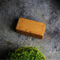 Teeny Greeny coir briquette growing medium flat lay surrounded by fresh microgreens in bambo trays