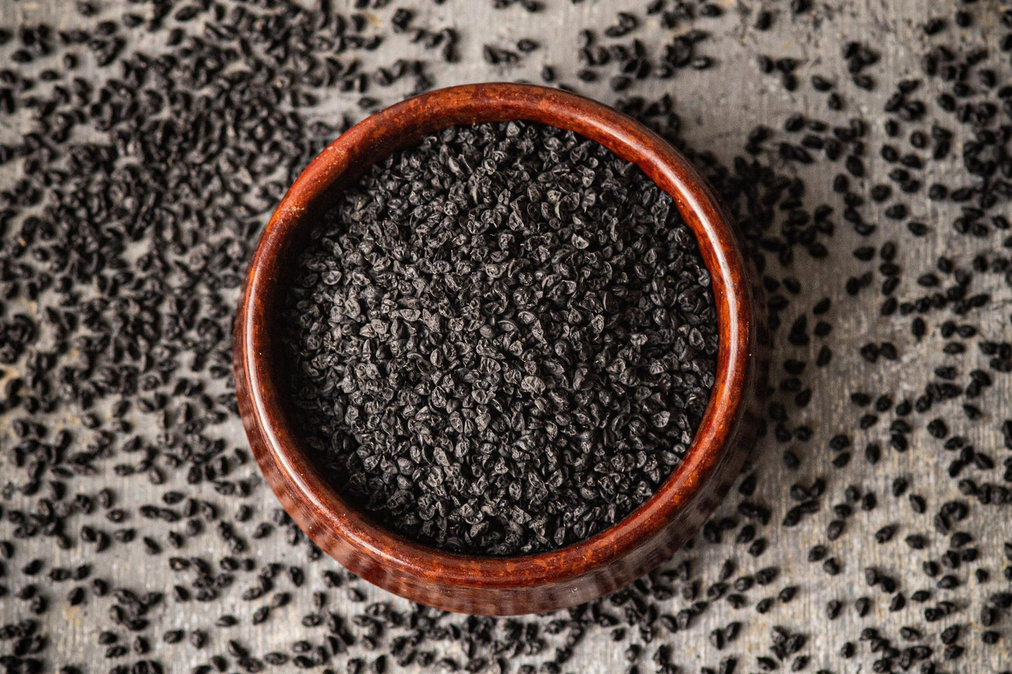 Teeny Greeny organic garlic chive microgreen seeds close up in wooden bowl on rustic surface