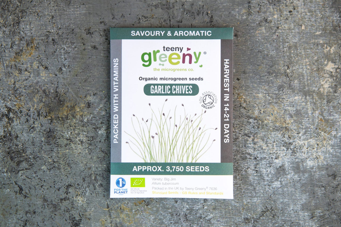 Teeny Greeny garlic chive organic microgreen seed packet standing upright on slate background