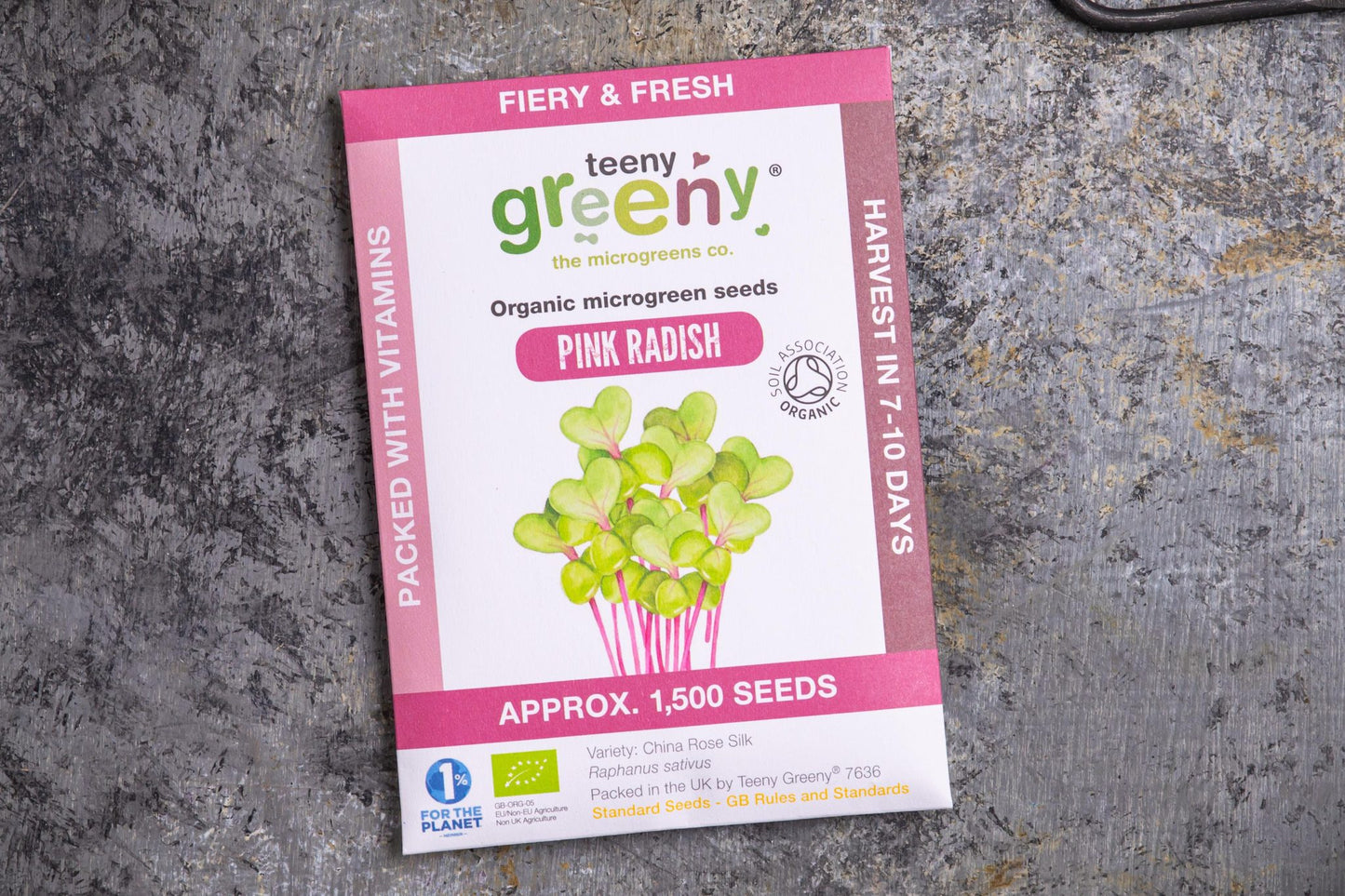Teeny Greeny organic pink radish microgreen seed packet flat lay on stone surface

