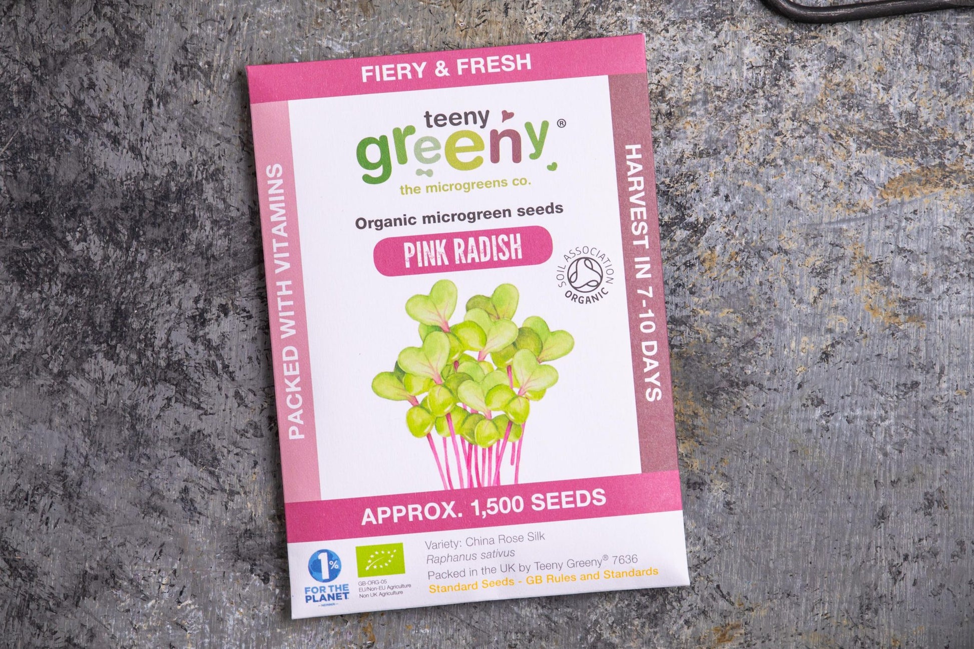 Teeny Greeny organic pink radish microgreen seed packet flat lay on stone surface
