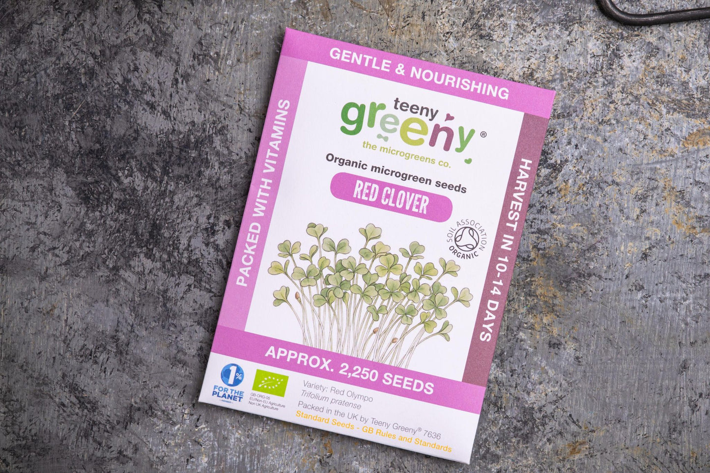 Teeny Greeny organic red clover microgreen seed packet flat lay on stone surface
