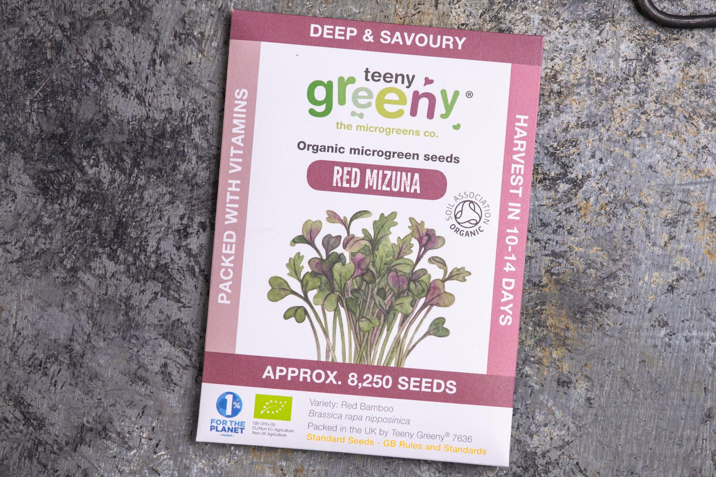 Teeny Greeny organic red mizuna microgreen seed packet flat lay on stone surface