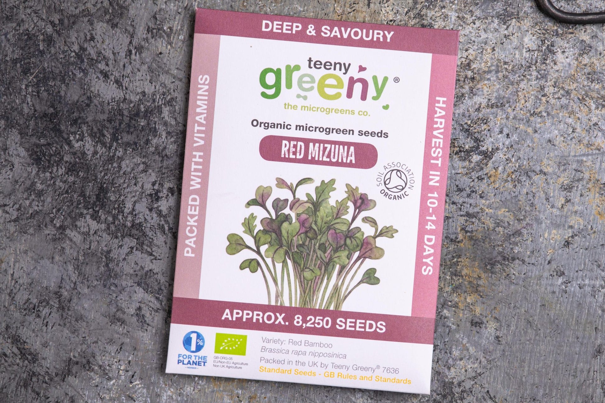 Teeny Greeny organic red mizuna microgreen seed packet flat lay on stone surface