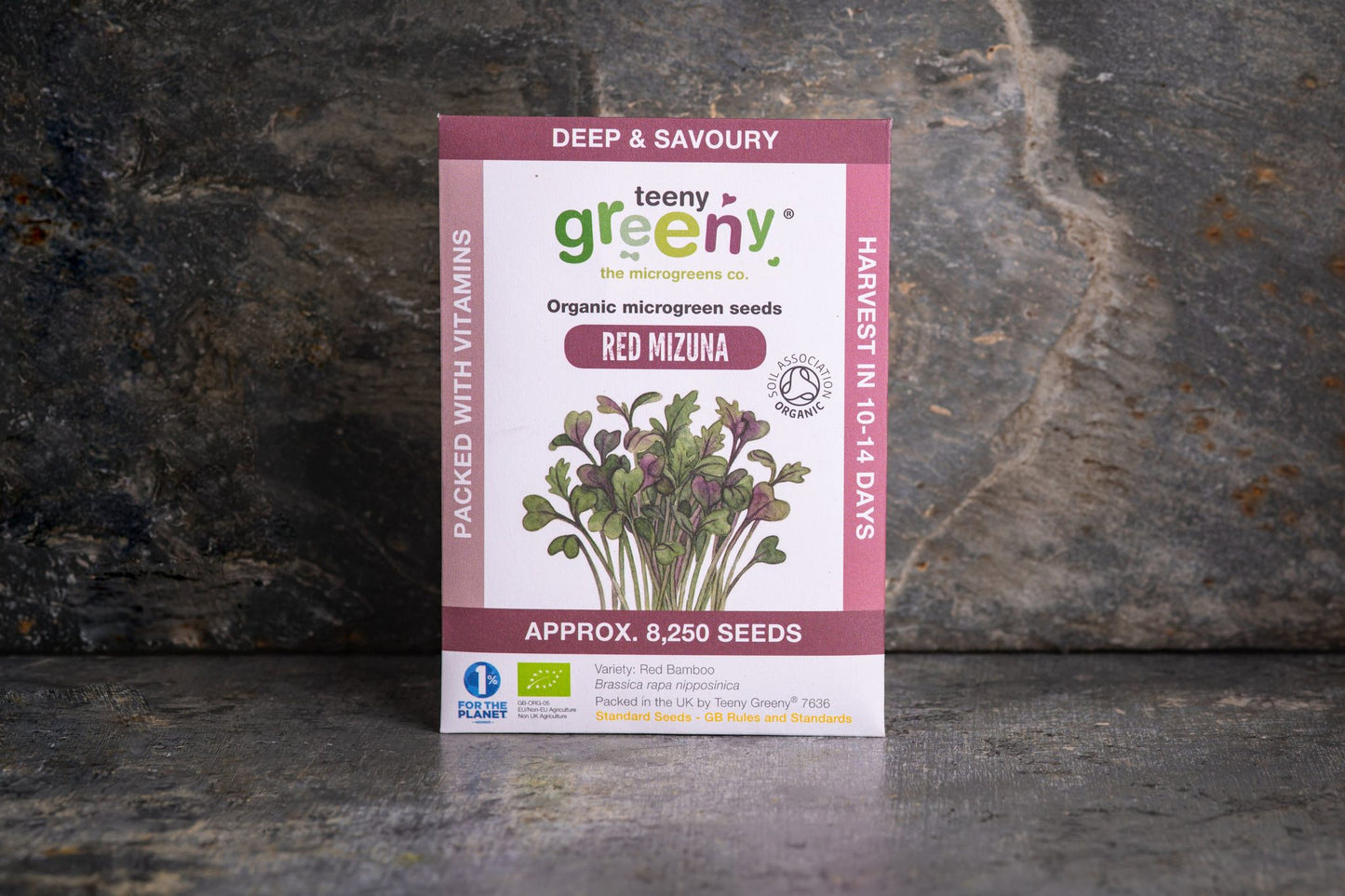 Teeny Greeny organic Red Mizuna microgreen seed packet standing upright on dark slate background