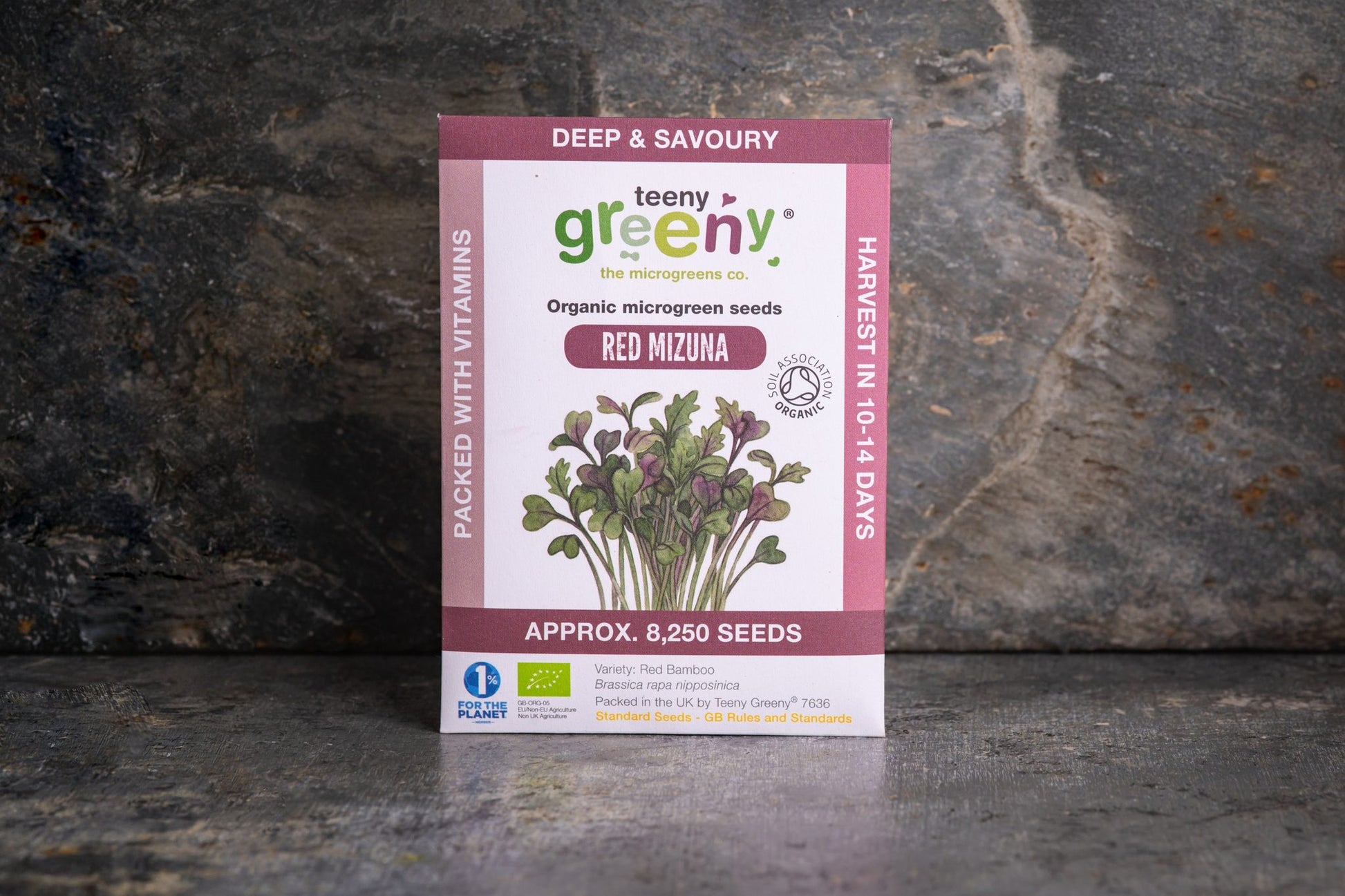 Teeny Greeny organic Red Mizuna microgreen seed packet standing upright on dark slate background
