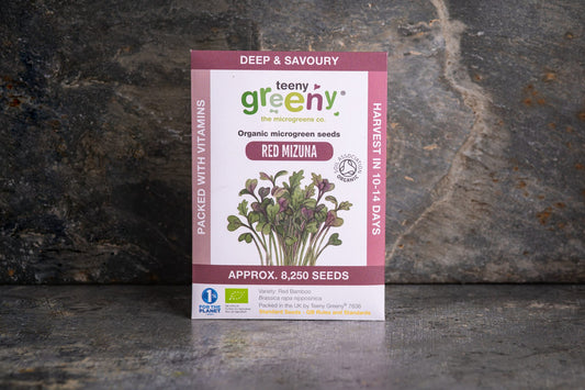 Teeny Greeny organic Red Mizuna microgreen seed packet standing upright on dark slate background
