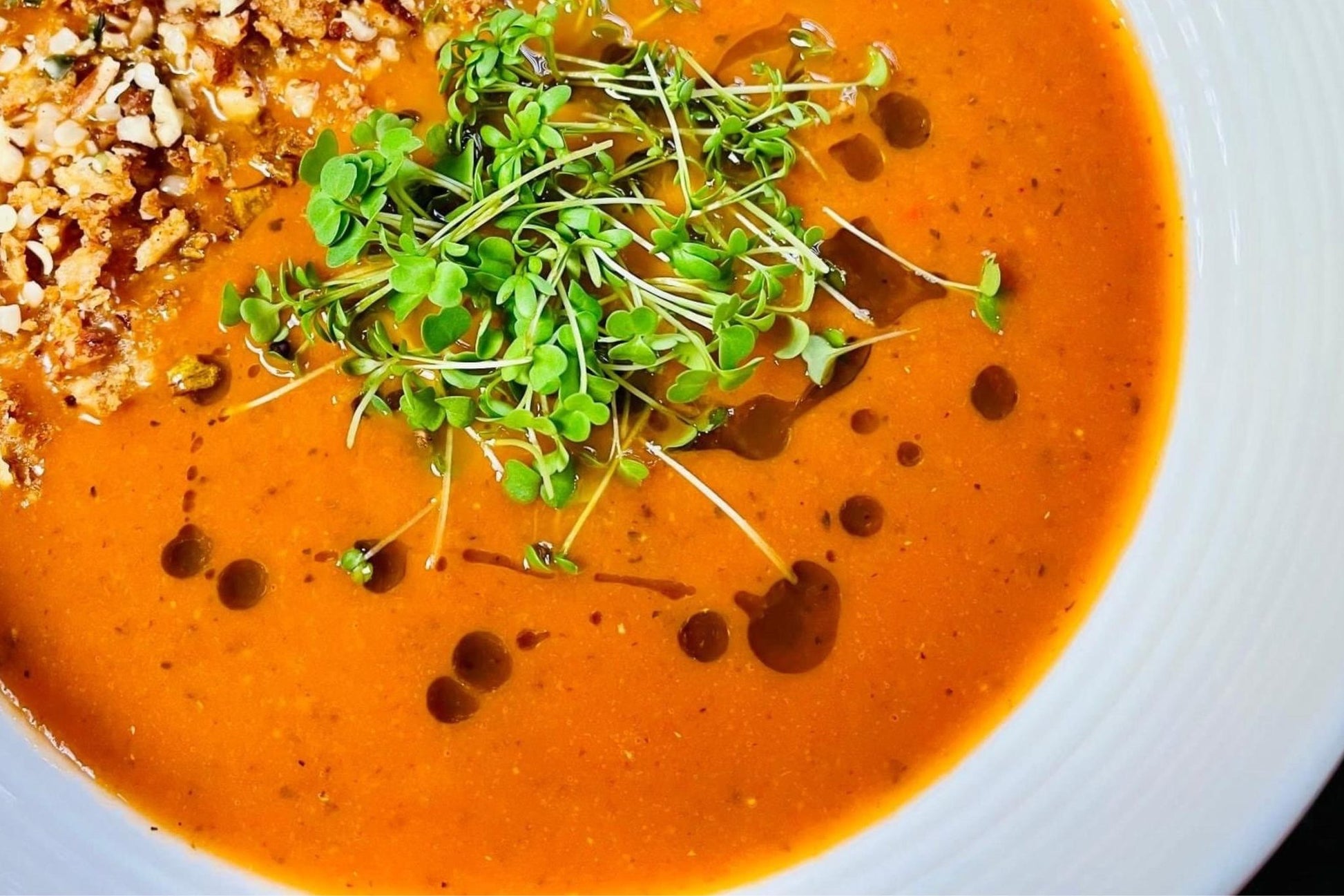Teeny Greeny rocket microgreens as fresh garnish on tomato soup with crushed nuts
